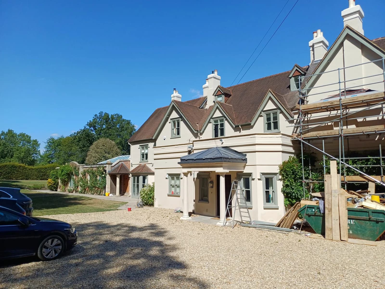 Large rendered Hampshire house being repainted by Bourne Decorators, with scaffolding up to the gable end